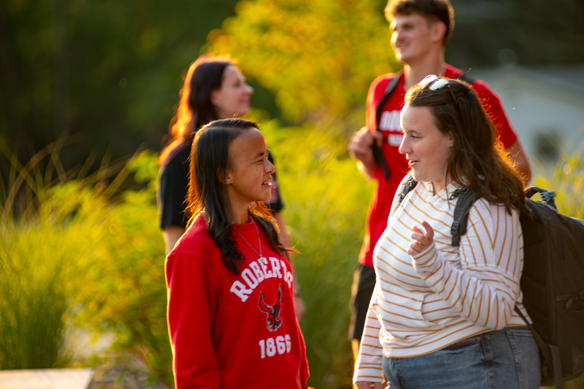 Students have a conversation outside on campus