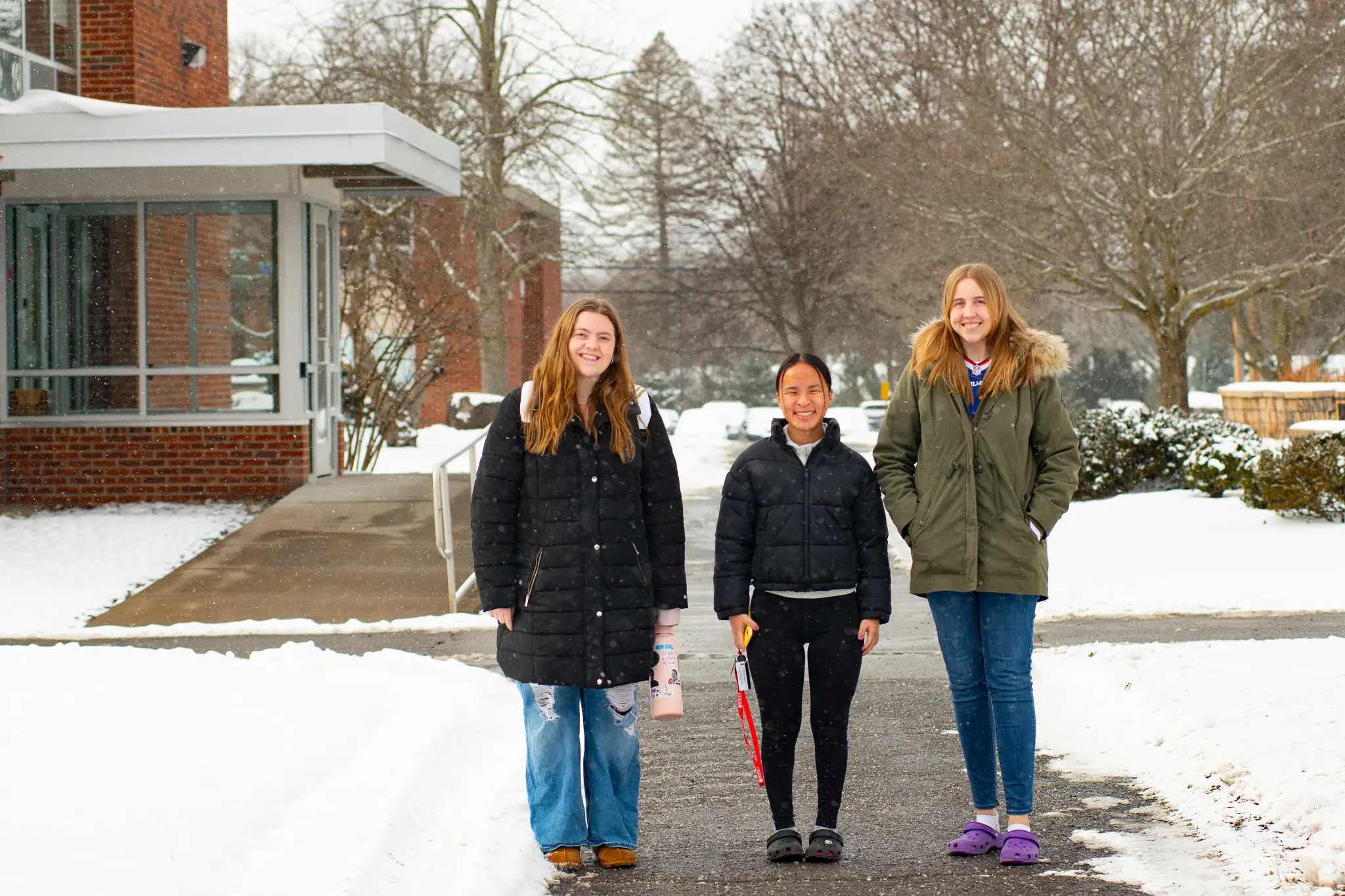 Students stand on campus in the snow